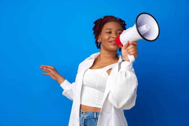 istock African american woman using megaphone against blue background 1325848874