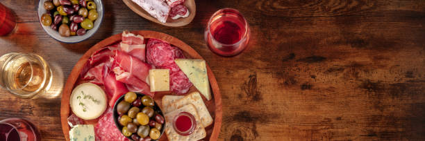 istock Charcuterie and cheese board panorama with red wine and olives 1325850355