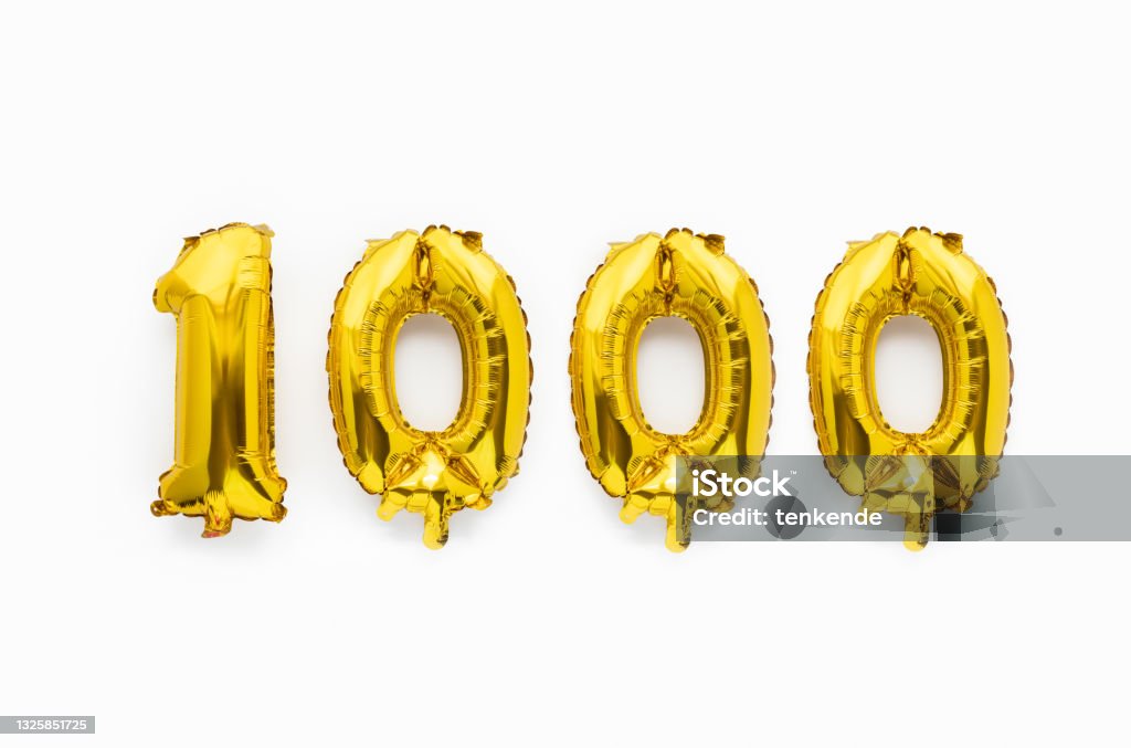 Number 1000 one thousand golden foil balloon party decor on white background, birthday anniversary Number 1000 one thousand golden foil balloon party decor on white background, birthday anniversary concept. Number 1000 Stock Photo