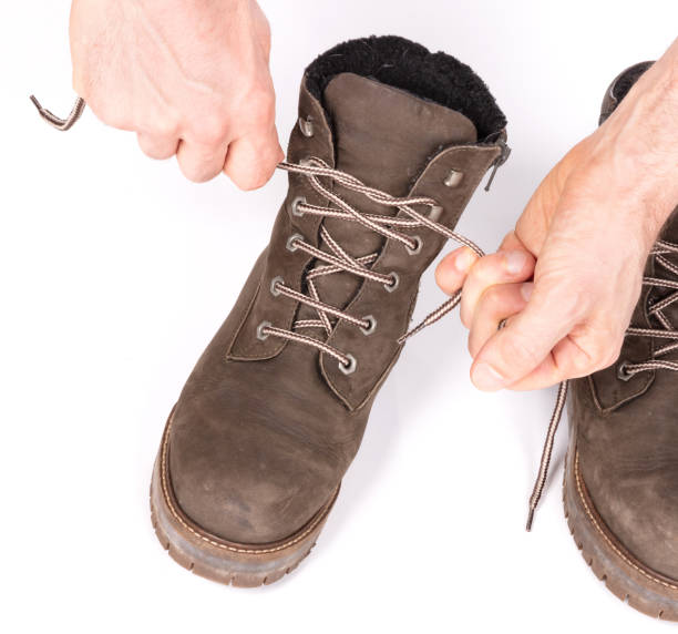 istock Tying laces of a hiking boot, isolated on white 1325852379