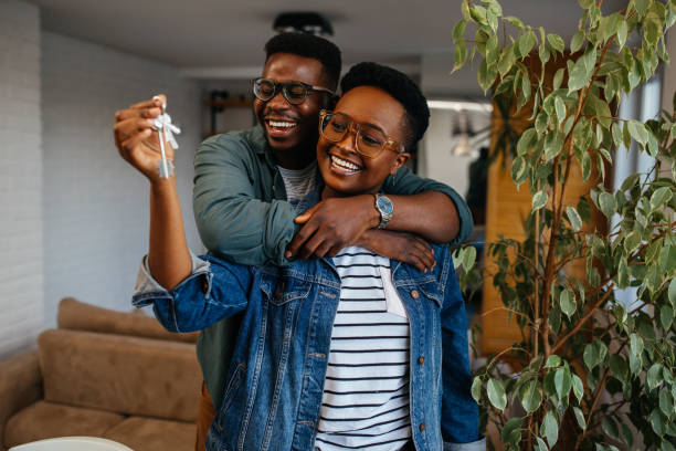 istock Couple cheerful home owners holding a key 1325852420