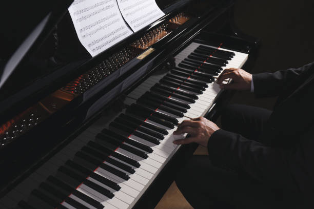 istock Man playing grand piano, closeup. Talented musician 1325852853