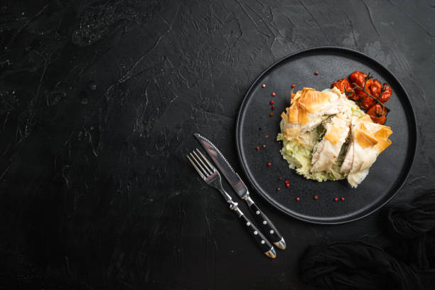 istock Russian cuisine stuffed chicken cutlets kiev style, with baked cherry tomatoes, mashed potatoes, on black stone background, top view flat lay, with copy space for text 1325852867