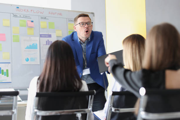 istock Woman pointing finger at surprised coach at business training 1325853007