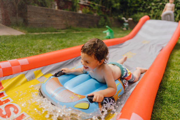 istock Little boy having fun on the water slide 1325854446