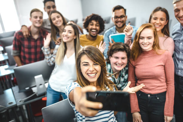 istock Happy students and their professor taking a selfie in computer lab. 1325854602