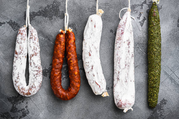istock Spanish dry salami from a rack at market on grey background 1325854698