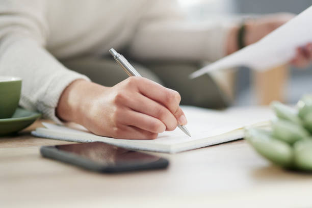 istock Closeup shot of an unrecognisable businesswoman writing notes while going through paperwork in an office 1325855588