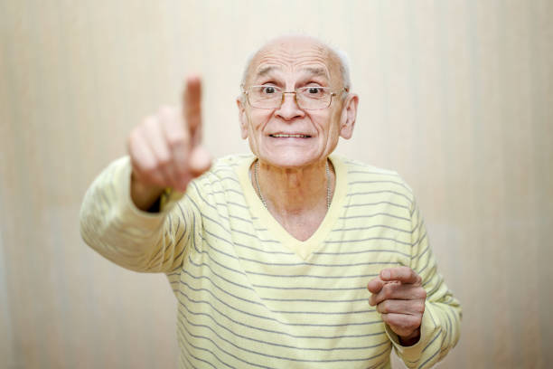 istock Aged old man wearing eyewear pointing finger up and smiling. 1325855823