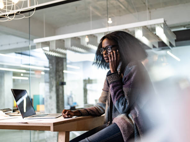 istock Young black freelancer talking on cell phone in the office. 1325855876