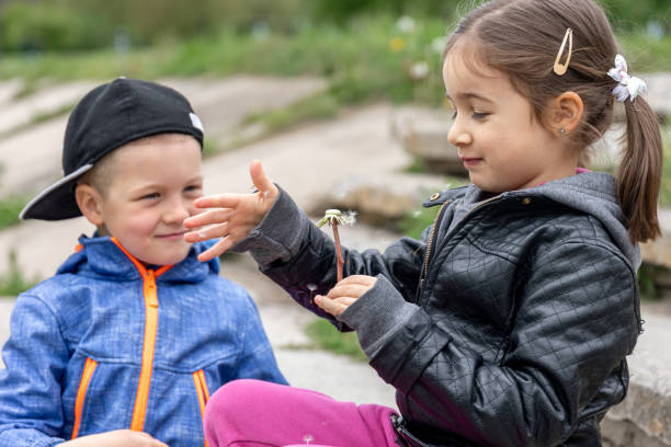 istock Two small children are playing with dandelions on a walk. 1325855883