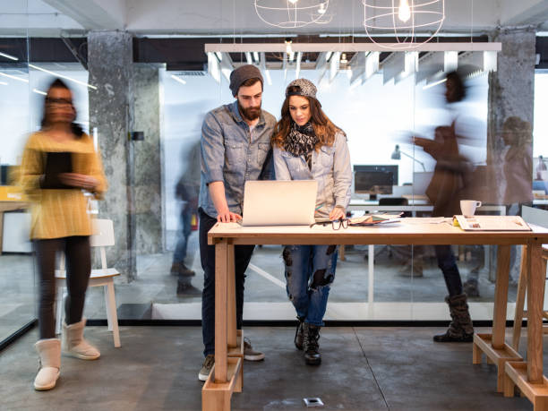 istock Creative colleagues working on laptop around people in blurred motion. 1325856056