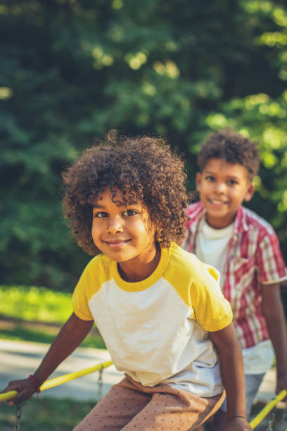 afroamerikanische kinder spielen auf brücke. bruder und schwester. der fokus liegt auf dem kleinen mädchen. - african ethnicity brother ethnic little boys stock-fotos und bilder