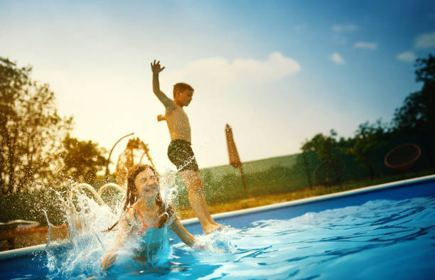 istock Kids having fun in a swimming pool. 1325857939