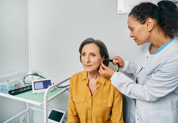 Tympanometry. Ent doctor doing tympanometry and test of middle-ear function to mature woman patient at hearing clinic Tympanometry. Ent doctor doing tympanometry and test of middle-ear function to mature woman patient at hearing clinic ear exam stock pictures, royalty-free photos & images