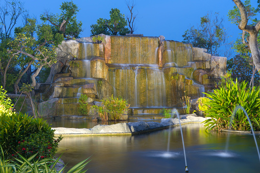 landscape of beautiful Artificial waterfall in garden at the public park in night time.