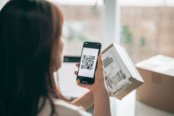 istock Asian woman scanning QR code of parcel 1325861682