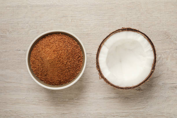 istock Natural coconut sugar in bowl on white wooden table, flat lay 1325863834