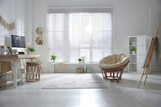 istock Stylish home office interior with comfortable workplace and papasan chair 1325864882