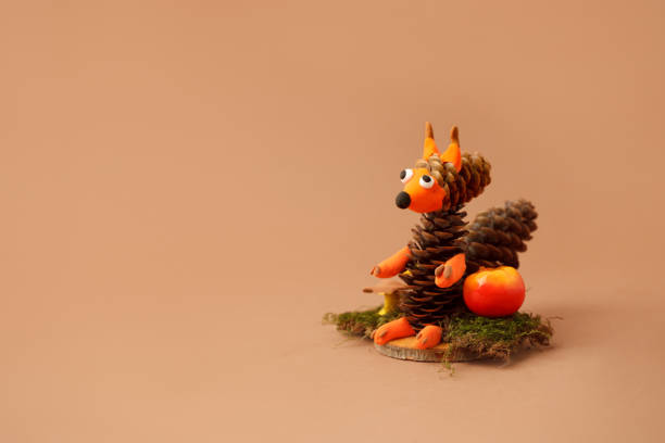 Autumn crafts. Children's fall crafts and creativity, Squirrel made from modeling clay, cones and nuts on dry stump. Ideas for children's art, hometime hobby, daycare education for kids