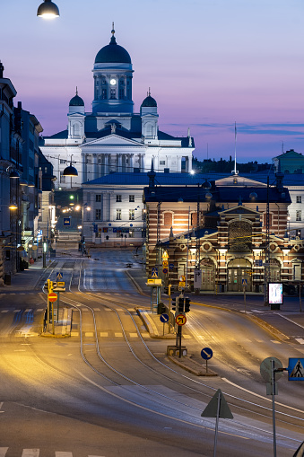 Helsinki / Finland - JUNE 22, 2021: Beautiful night cityscape of downtown Helsinki. The Helsinki Cathedral in the background and illuminated Market Hall in the foreground.