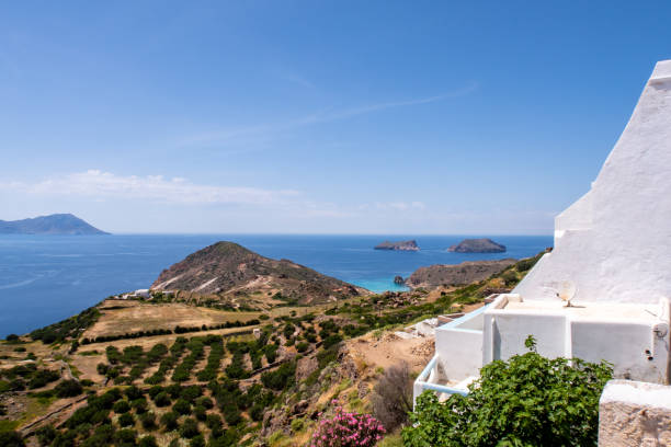 Sea view from Plaka Town on Milos Island, Greece. Sea view from Plaka Town on Milos Island, Greece, with whitewashed traditional houses and green vineyards on the foreground and crystal blue sky. aegean islands stock pictures, royalty-free photos & images