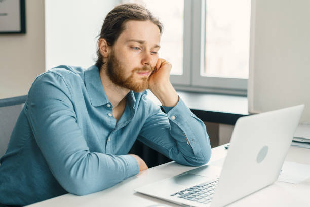 istock Unhappy male office worker feeling bored at work 1325869805