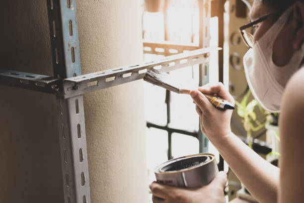自分でコンセプトを行い、職人は古い鉄の部品をペイントするために防錆塗料を使用しています。あなたの自由な週末に棚を作る - rust free ストックフォトと画像