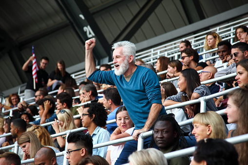 Argentinian spectators in stadium cheering their national football team. People from Argentina in fan zone cheering for their soccer team.