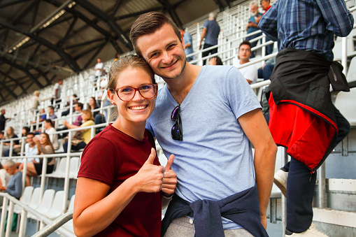Young man and woman coming to a stadion event.