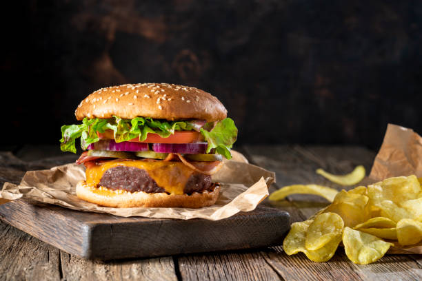 istock Cheeseburger Burger Patty classic with potato chips menu on rustic table of wood 1325880602