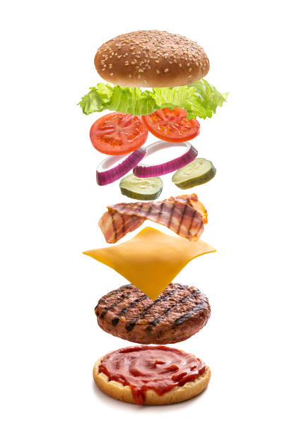 istock Burger layered ingredients as explosion flying open bun isolated on white 1325880653