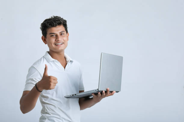 joven indio usando computadora portátil. - indian culture manager men asian ethnicity fotografías e imágenes de stock