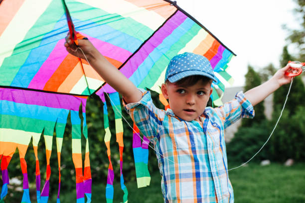 istock preschool boy flying a flying kite in the backyard 1325881488