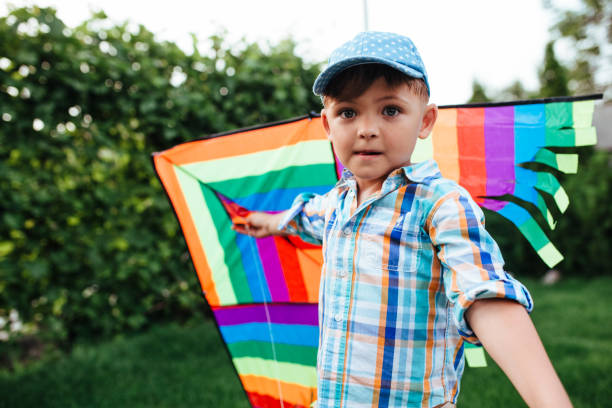istock preschool boy flying a flying kite in the backyard 1325881649