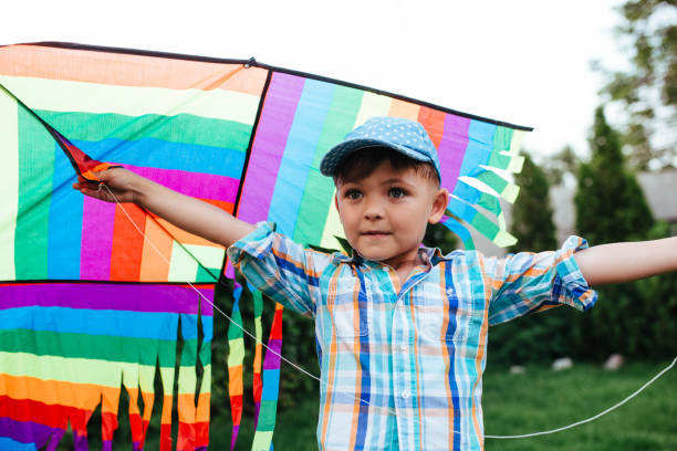 istock preschool boy flying a flying kite in the backyard 1325881986