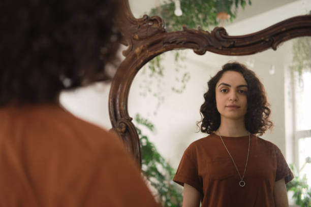istock Woman looking at mirror 1325882035