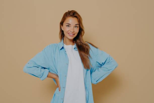 istock Image of self assured smiling lovely model keeps hands on waist 1325882262