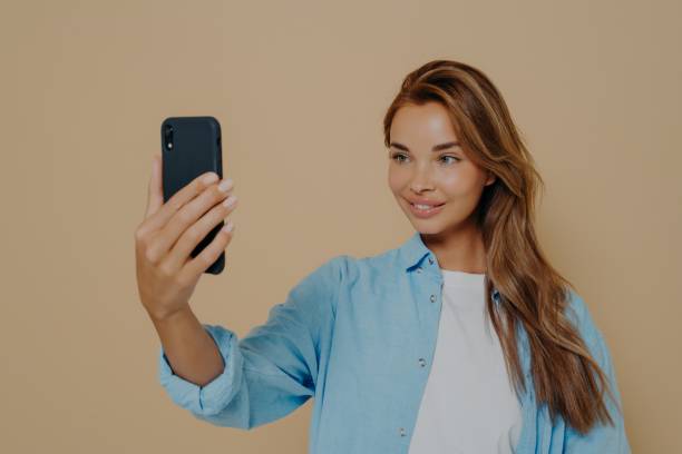 istock Adorable female model poses for making selfie in studio 1325882340
