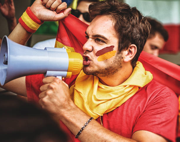 istock spanish supporter with the megaphone and face painted 1325884713