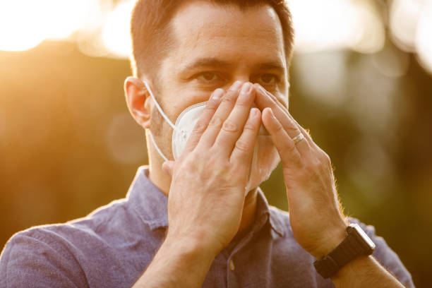 istock Man adjusting N95 face mask he is wearing 1325887679