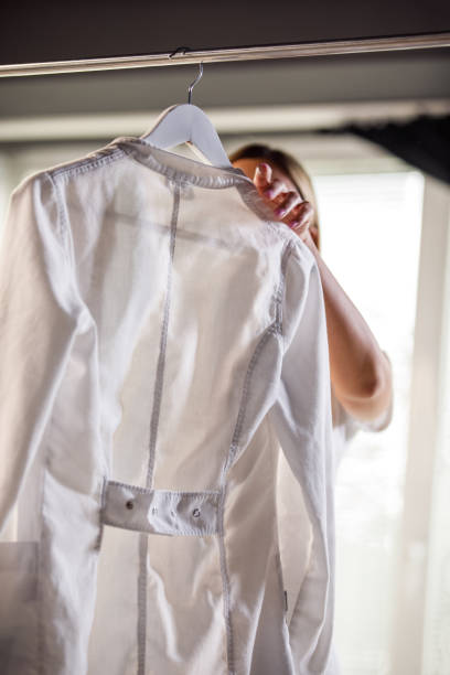 Female doctor getting her lab coat from clothing rack
