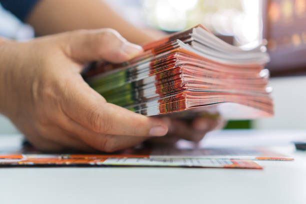 istock Business Brochure in Documents concept : Businessman hands working in stacks brochures paper files for checking document achieves reports on busy work desk office 1325889770