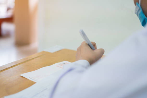 istock Female asian student study together reading document wearing facemask prevent COVID-19 coronavirus, Taking exam test at classroom high school of Thailand Concentration admission SAT PISA in evaluation 1325889813