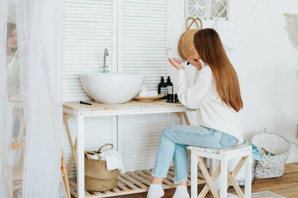 istock woman sitting near sink and doing makeup 1325890905