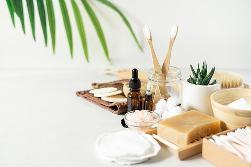 Natural bathroom and home spa tools. Zero waste sustainable lifestyle concept. Bamboo toothbrush, natural soap bar, cotton pads, homemade DIY beauty products in reusable bottles on white background