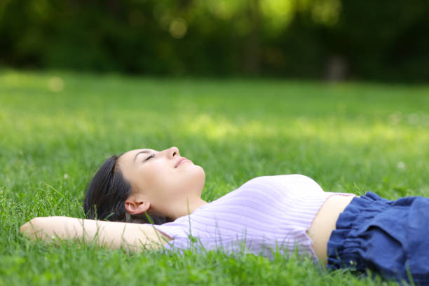 istock Mixed race woman relaxing lying on the grass 1325895729
