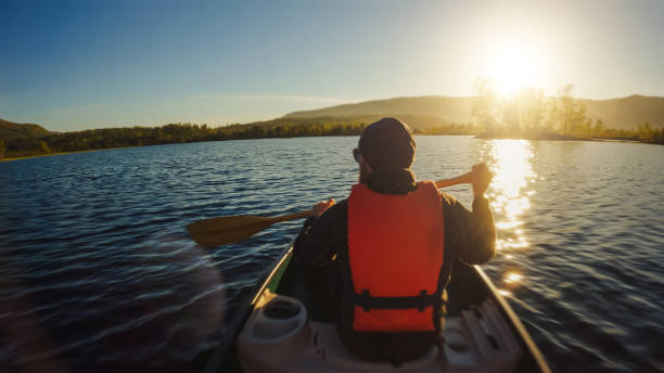 istock Outdoor adventures: POV canoeing in a lake at sunset 1325896799