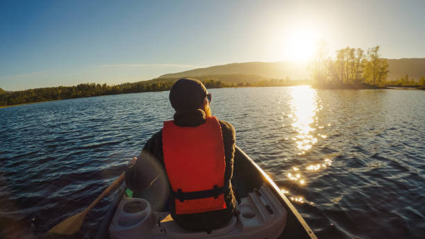 istock Outdoor adventures: POV canoeing in a lake at sunset 1325896829
