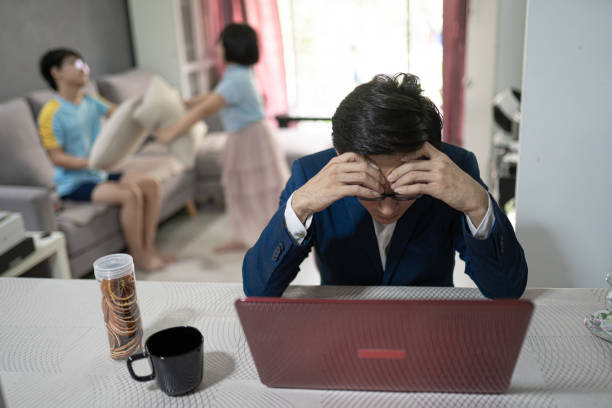 asian chinese man work at home. children were having playing in pillow fights. father loss concentration and frustrated. - inconvenience meeting business distracted imagens e fotografias de stock